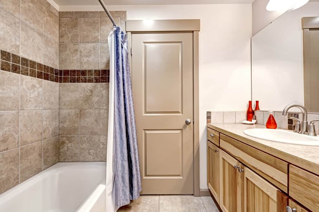 bathroom with tile wall trim with shower curtain